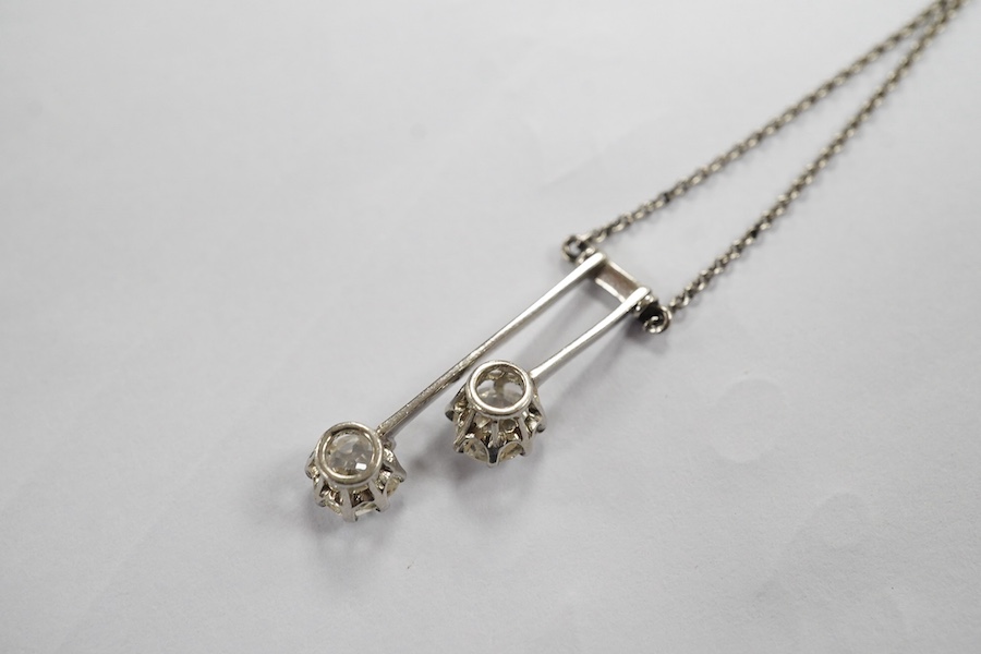 A two stone diamond articulated pendant, on a fine white metal chain. Condition - fair